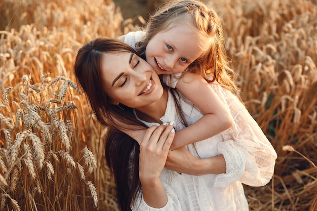 Family in a summer field. Sensual photo. Cute little girl. Woman in a white dress.