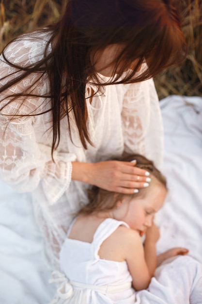 Free Photo family in a summer field. sensual photo. cute little girl. woman in a white dress.