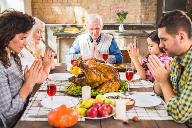 Free Photo family at table praying before meals