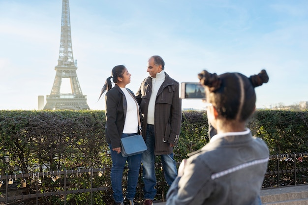 Free photo family taking a picture in their travel to paris