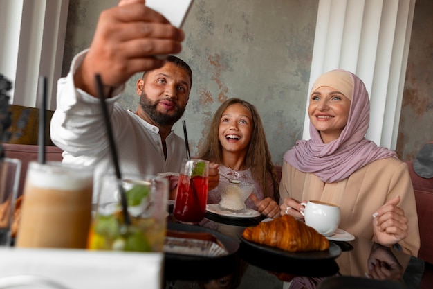 Free photo family taking selfie together while out at a restaurant