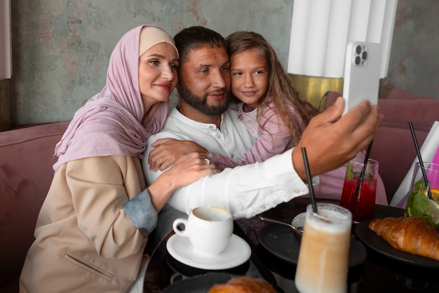 Free Photo family taking selfie together while out at a restaurant