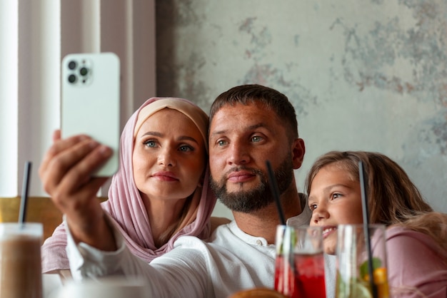 Free photo family taking selfie together while out at a restaurant