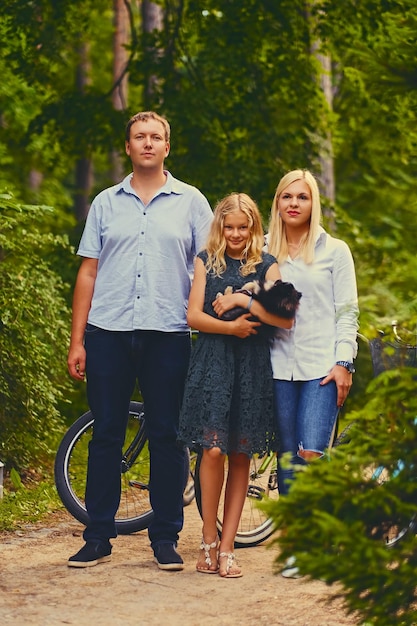 A family and their Spitz dog in a park.