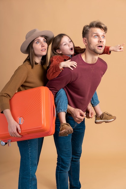 Free photo family of three ready for a travel vacation together with luggage