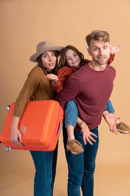 Family of three ready for a travel vacation together with luggage