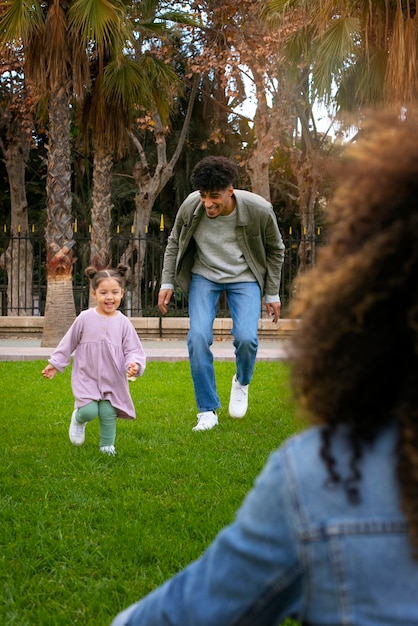 Free photo family of three spending time together outdoors on father's day