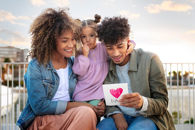 Free photo family of three spending time together outdoors on father's day