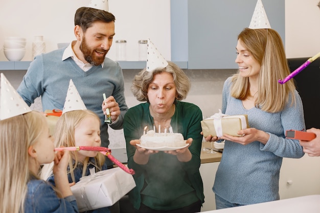 Free photo family and two their daughters have a celebration of grandmothers birthday old woman blowing out the candles