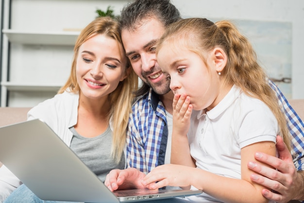 Free photo family using the laptop on the sofa