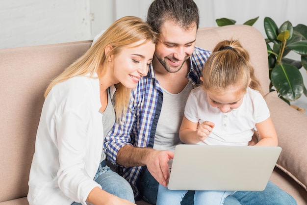 Free photo family using the laptop on the sofa