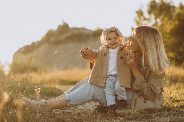 Family walks in a field Little girl child in the summer meadow Woman in a white shirt