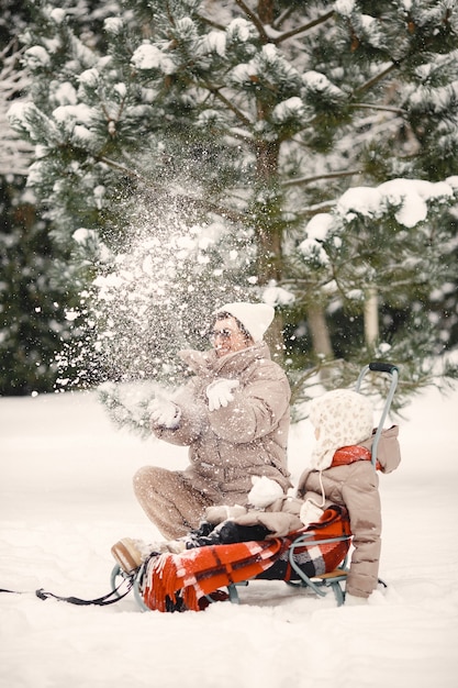 Free photo family in winter clothes on vacation in snowy forest