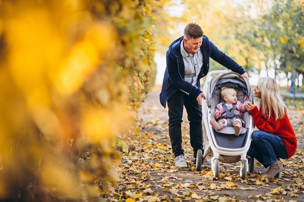 Family with baby daugher walking in an autumn park