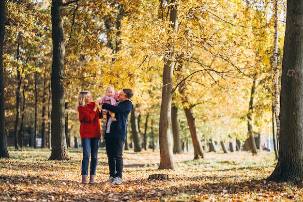 Family with baby daugher walking in an autumn park