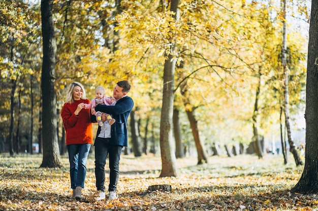 Free photo family with baby daugher walking in an autumn park