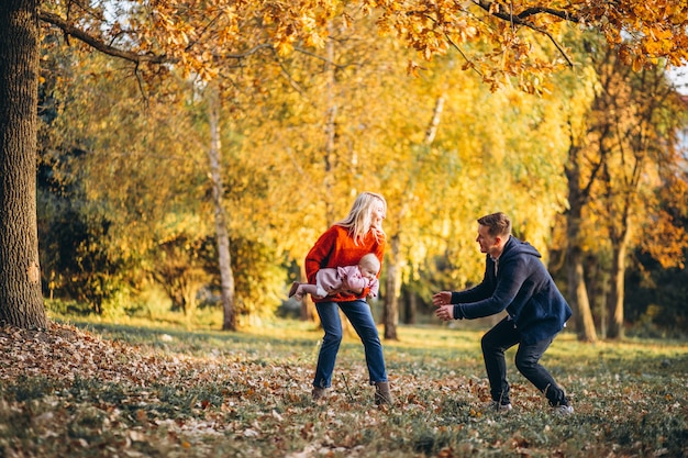 Family with baby daughter walking in an autumn park