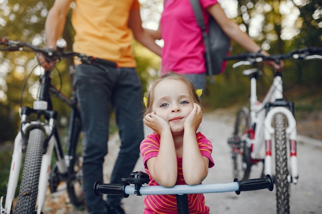 Free photo family with a bicycle in a summer park