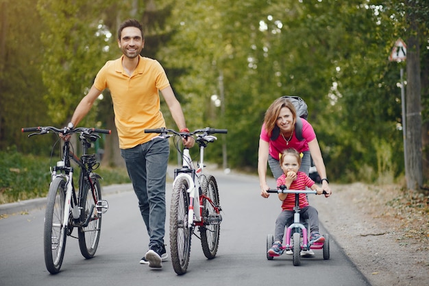 Free photo family with a bicycle in a summer park