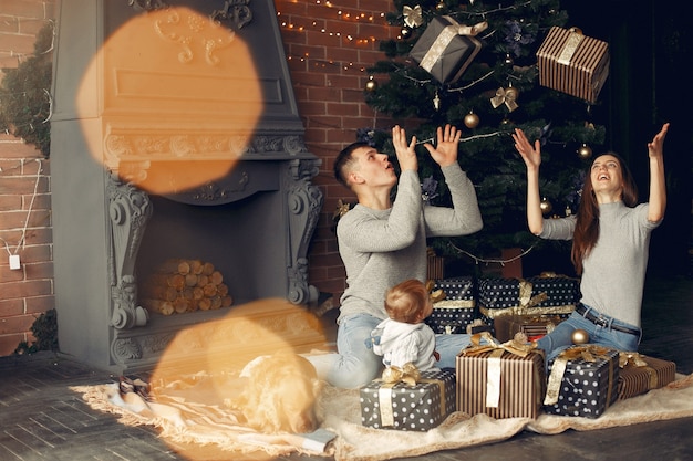 Family with cute dog at home near christmas tree