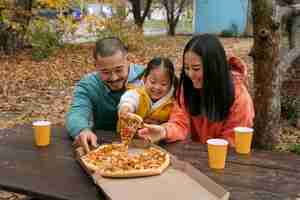 Free photo family with delicious pizza outdoors front view