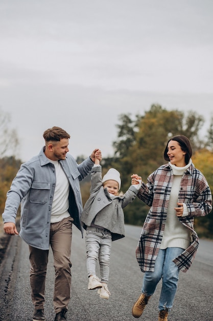 Family with little daughter together in autumnal weather having fun