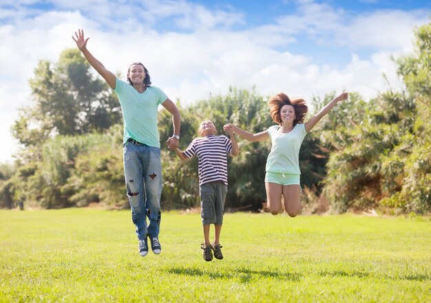 family  with teenage boy jumping in  park