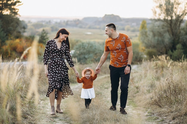 Family with their little daughter in an autumn field