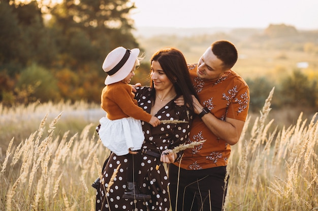 Family with their little daughter in an autumn field