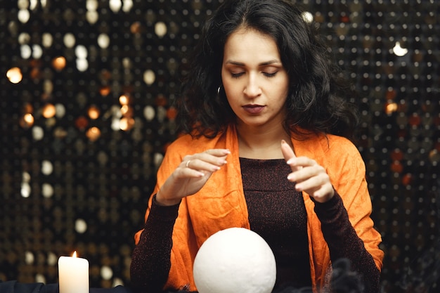 Free photo fantasy beautiful gypsy girl. fortune teller woman reading future on magical tarot cards.