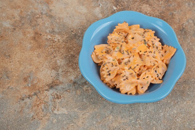 Farfalle pasta with cheese sauce on orange background. High quality illustration