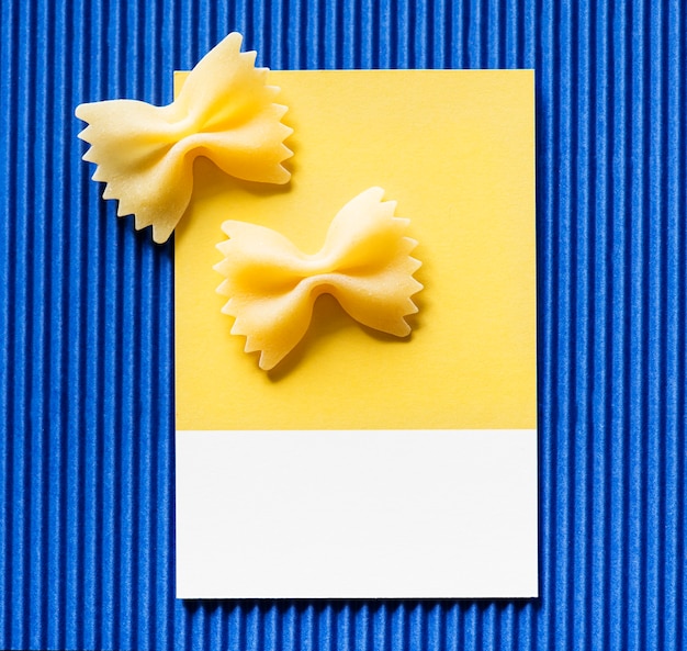 Free photo farfalle pasta on a yellow card