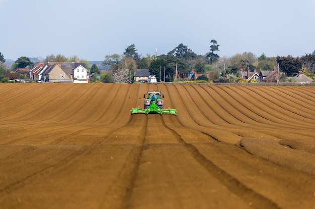 Farm combine harvester in a large agricultural field during COVID-19 pandemic