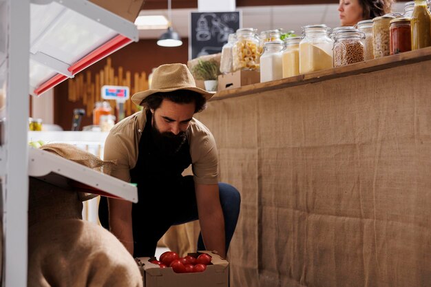 Farmer bringing crates full of vegetables from his own renewable energy powered farm to zero waste supermarket Supplier restocks local neighborhood store with sustainable handpicked food items