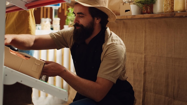 Free photo farmer refills supermarket with veggies