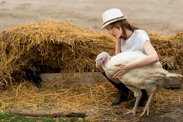 Free photo farmer with a turkey in a farm