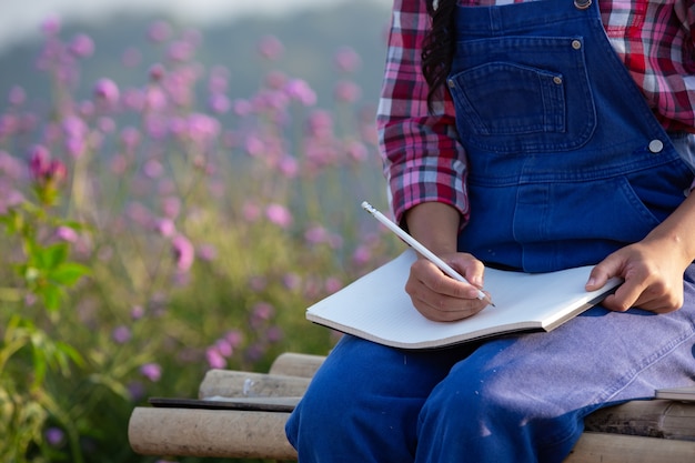 Free Photo farmers women are taking notes in the flower garden.