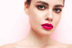 Free photo fashion beauty portrait of young brunette woman with evening stylish makeup and perfect clean skin sexy model with hair in a bun posing in studio with pink bright natural lips