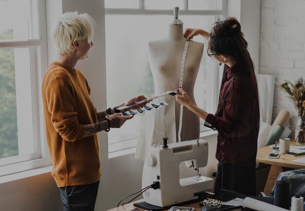 Fashion designer using a measuring tape on a mannequin