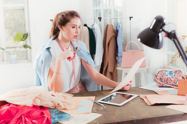 Free photo fashion designers working in studio sitting on the desk