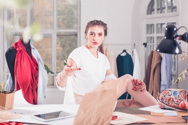 Free photo fashion designers working in studio sitting on the desk