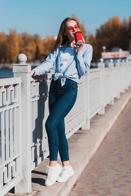 Free Photo fashion dressed woman holding a cup of coffee