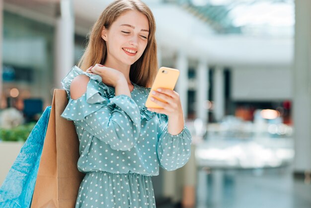 Fashion girl checking phone in mall