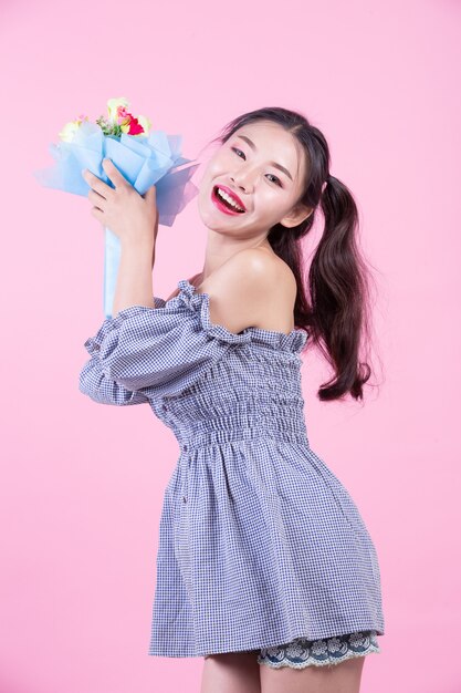 Fashion girl dress up with hand gestures on a pink background.