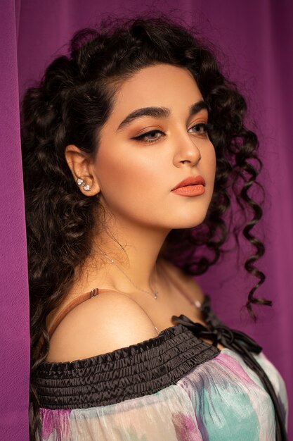 Fashion model with curly black hairs and light makeup