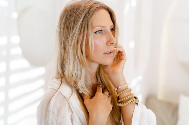 Fashion photo of beautiful blond woman in white summer clothes posing in modern hotel during vacations