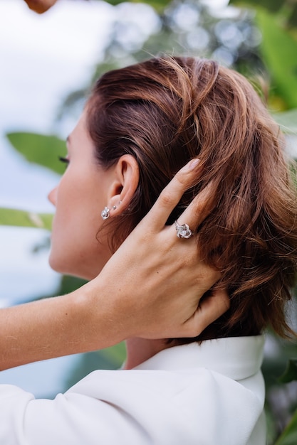 Free Photo fashion portrait of woman at tropical luxury villa wearing white stylish blazer and jewellery over tropical leaves