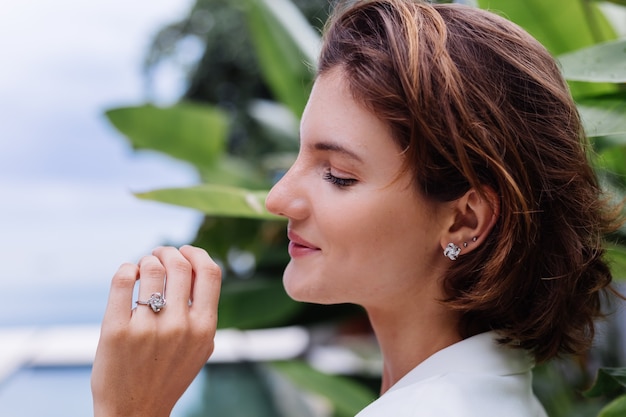 Free Photo fashion portrait of woman at tropical luxury villa wearing white stylish blazer and jewellery over tropical leaves