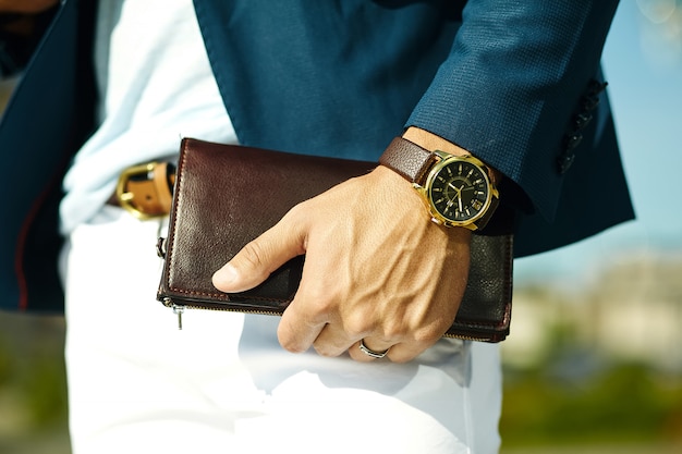 Fashion portrait of young businessman handsome model man in casual cloth suit with accessories on hands