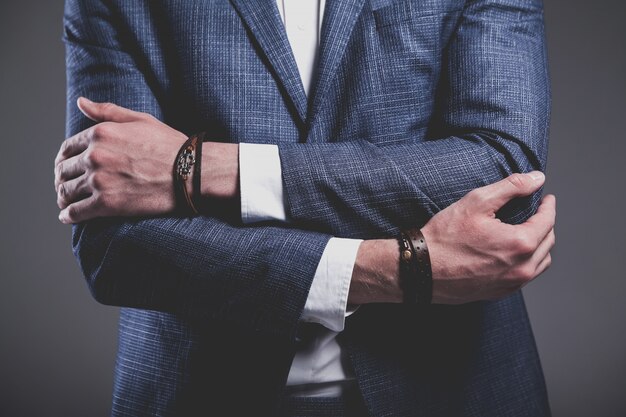 Fashion portrait of young businessman handsome model man dressed in elegant blue suit on gray